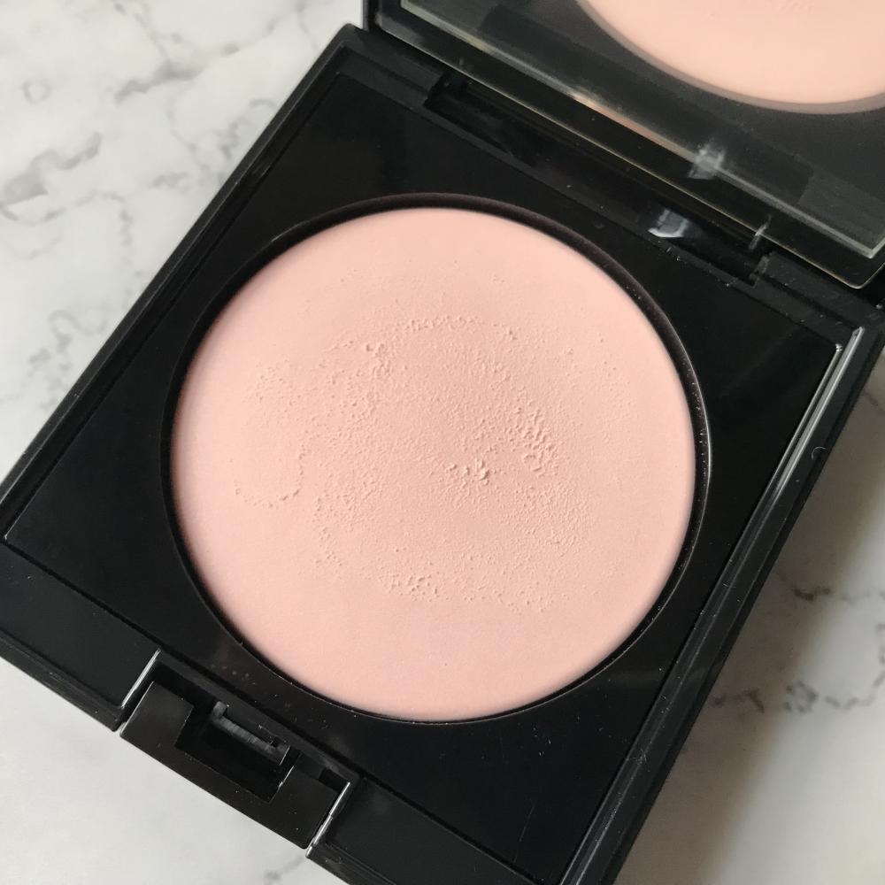 アディクション スキンリフレクトセッティングパウダー 002 Translucent Pinkの表面を軽く擦ってパウダーの柔らかさを見せています。