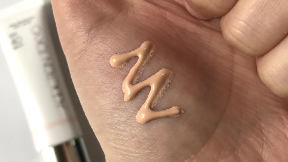 アディクション スキンプロテクターソフトグロウ 002 Nudy Apricotを手に出して色味を見せています。