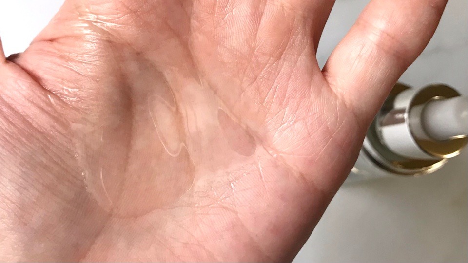 コスメデコルテ AQ毛穴美容液オイルを手に出してテクスチャーを見せています。